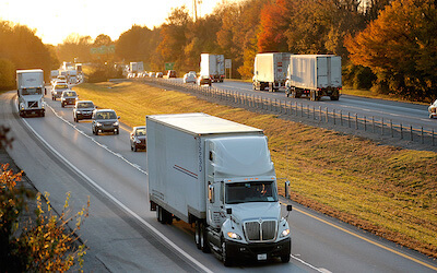 White tractor trailers on busy highway at sunset 2290 tax form