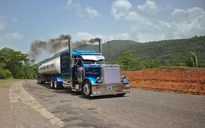 Blue tractor trailer on road DOT number