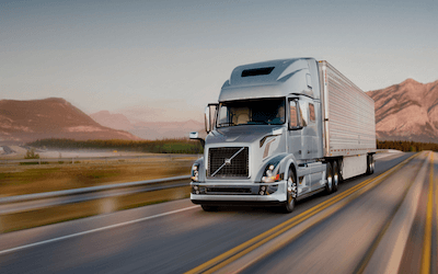 Silver Tractor Trailer driving on highway in new mexico with new mexico truck weight distance permit